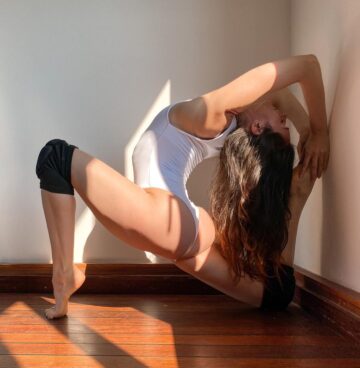 LINDELL ⋆ YOGA Onelegged kingpigeonpose on tiptoes against the wall